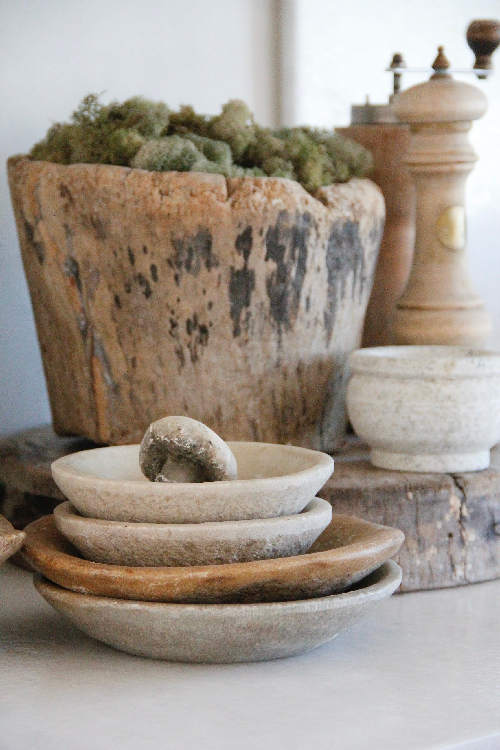 Set of rustic stone bowls on a wooden surface with a textured background